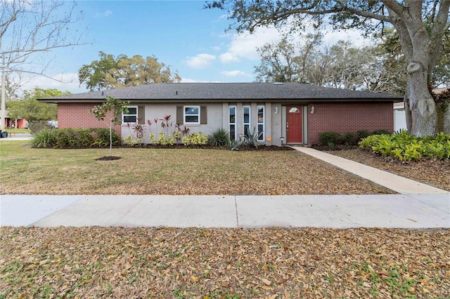 ranch-style home with brick siding and a front lawn