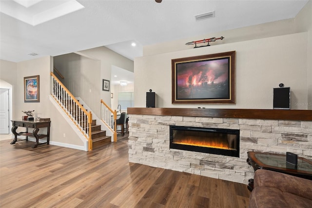 living room featuring hardwood / wood-style flooring and a stone fireplace