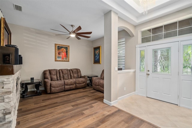 foyer featuring ceiling fan with notable chandelier and light hardwood / wood-style floors