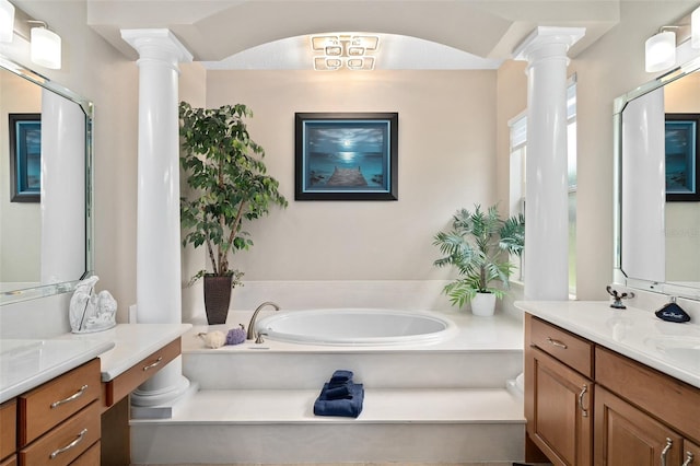 bathroom with a tub to relax in, vanity, and ornate columns