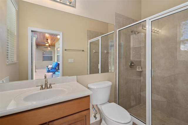 bathroom with walk in shower, vanity, and toilet