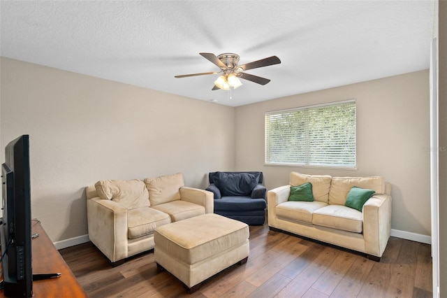 living room featuring ceiling fan, dark hardwood / wood-style flooring, and a textured ceiling