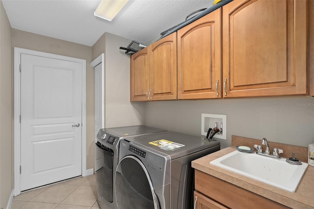 washroom featuring separate washer and dryer, sink, cabinets, and light tile patterned flooring