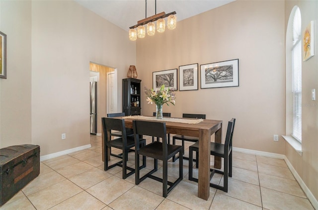tiled dining space with a high ceiling