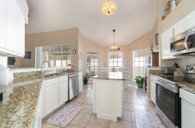 kitchen featuring sink, hanging light fixtures, light stone countertops, and stainless steel appliances