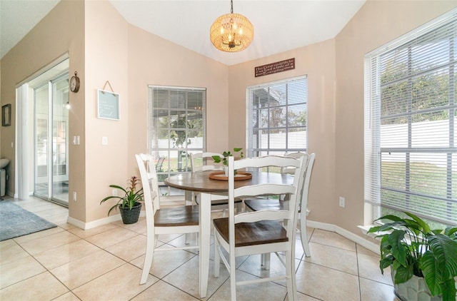 tiled dining space with lofted ceiling and a chandelier