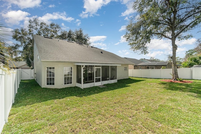 rear view of house with a sunroom and a lawn