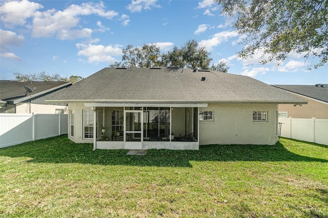 back of property featuring a yard and a sunroom