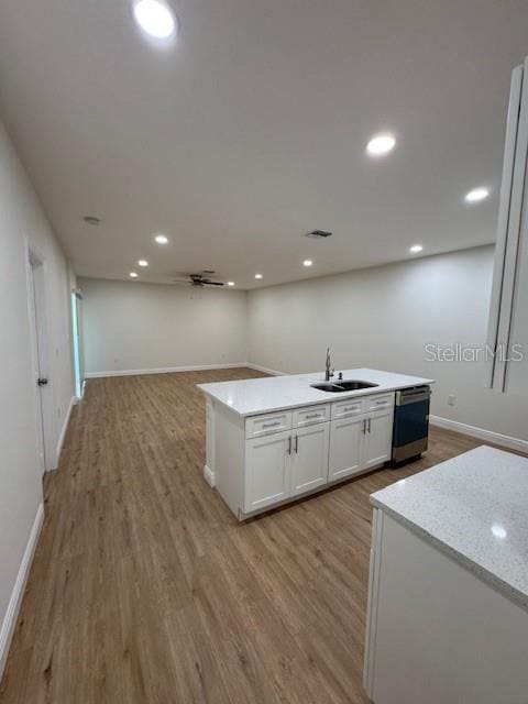 kitchen featuring light hardwood / wood-style flooring, dishwasher, a center island with sink, and white cabinets