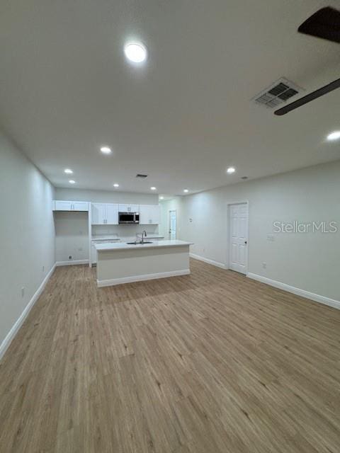 unfurnished living room with sink and light wood-type flooring