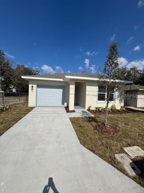 ranch-style house featuring a garage and a front yard