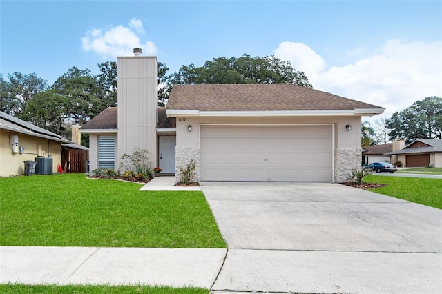 ranch-style home with a garage, a front yard, and central AC unit