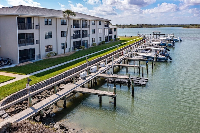 view of dock featuring a yard, a water view, and boat lift