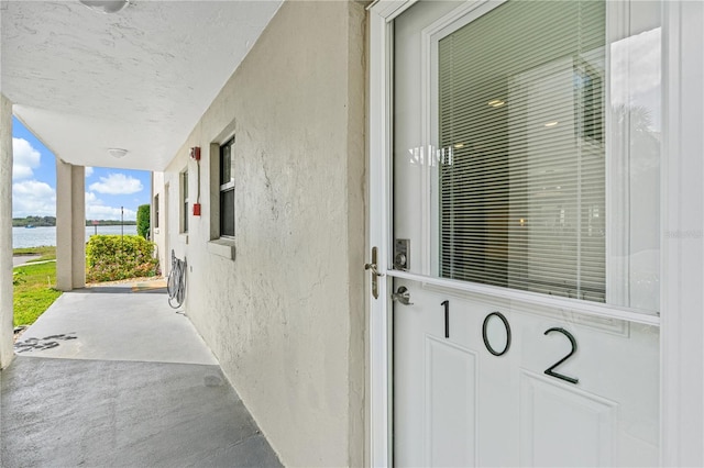 entrance to property featuring stucco siding and a water view