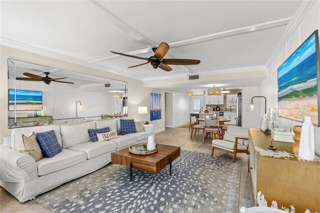 living room with crown molding, wood finished floors, and ceiling fan