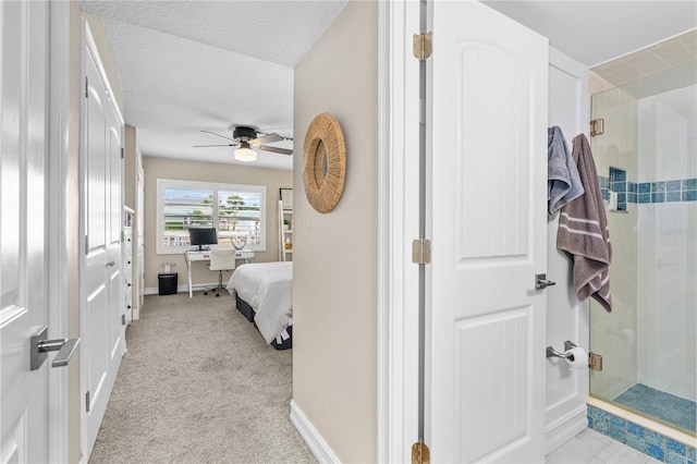 bedroom with light colored carpet, a textured ceiling, baseboards, and a ceiling fan