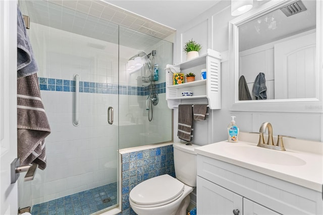 full bath with visible vents, a shower stall, vanity, and toilet