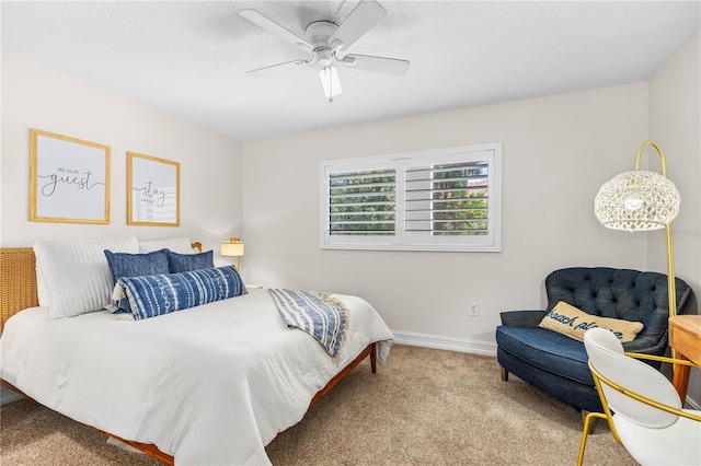 bedroom featuring baseboards, carpet floors, a textured ceiling, and ceiling fan