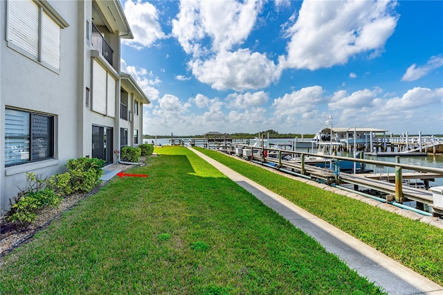 view of yard featuring boat lift, a floating dock, and a water view