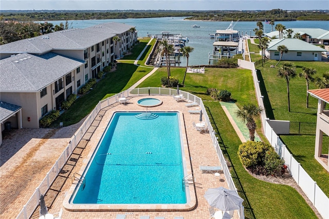 community pool featuring a water view and fence