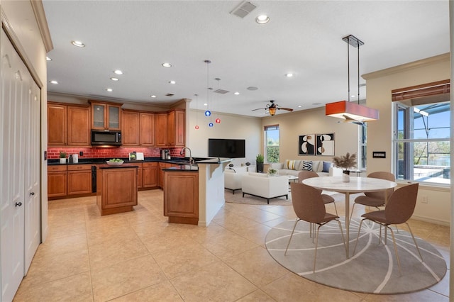 kitchen featuring black microwave, visible vents, open floor plan, brown cabinetry, and dark countertops