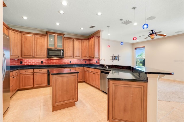 kitchen featuring a center island, visible vents, appliances with stainless steel finishes, a sink, and a peninsula