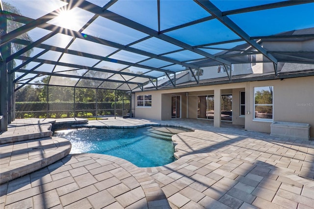 pool featuring glass enclosure and a patio