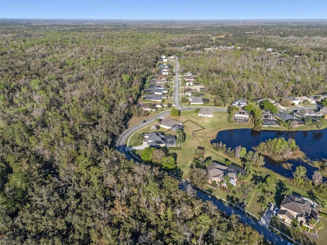 drone / aerial view with a residential view, a water view, and a wooded view