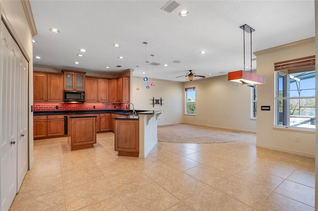 kitchen with black microwave, visible vents, open floor plan, brown cabinetry, and dark countertops