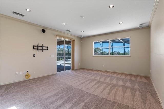 unfurnished room with carpet floors, baseboards, visible vents, and ornamental molding