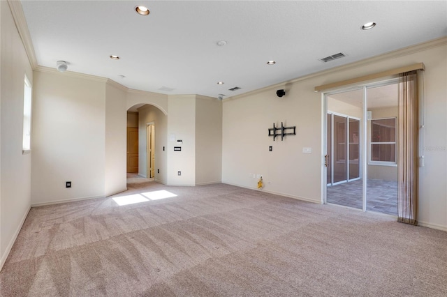 empty room featuring arched walkways, recessed lighting, visible vents, and light colored carpet