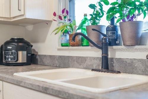 details featuring light stone countertops and sink