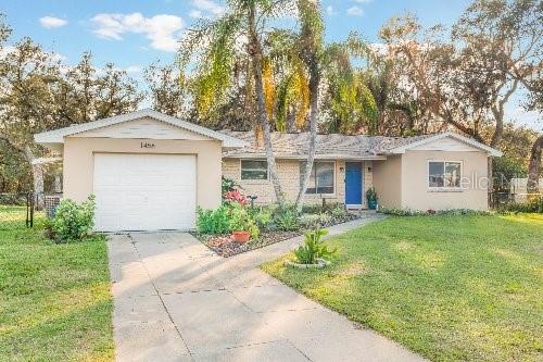 single story home with a garage and a front lawn