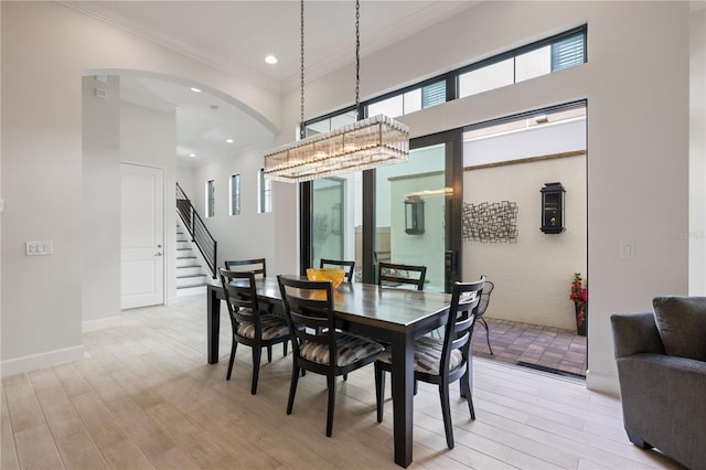 dining room with ornamental molding and light wood-type flooring