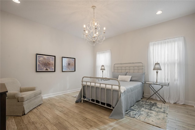 bedroom with light hardwood / wood-style floors and multiple windows