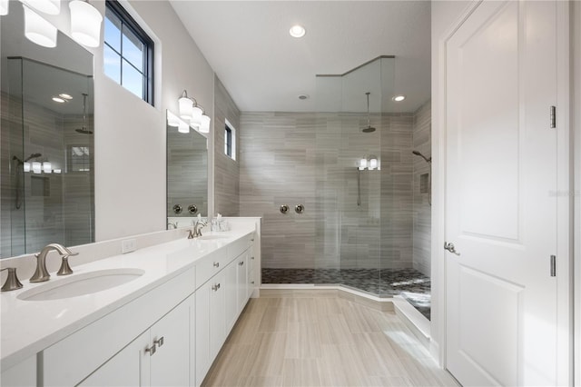 bathroom featuring vanity, a healthy amount of sunlight, and a shower with shower door