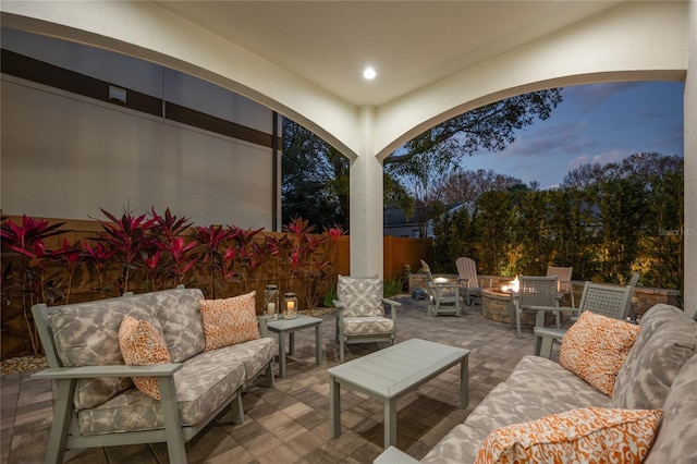 patio terrace at dusk with an outdoor living space with a fire pit