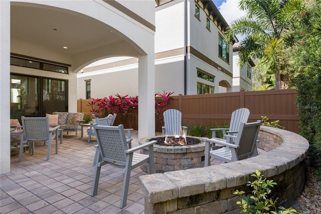 view of patio with an outdoor living space with a fire pit