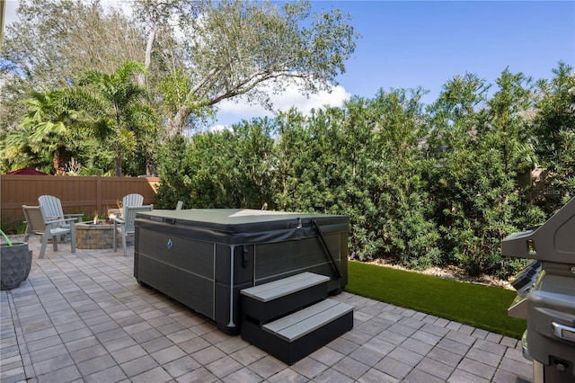 view of patio / terrace featuring a hot tub and a fire pit