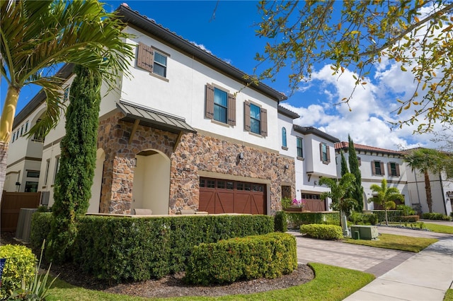 mediterranean / spanish-style home featuring a garage and central AC unit