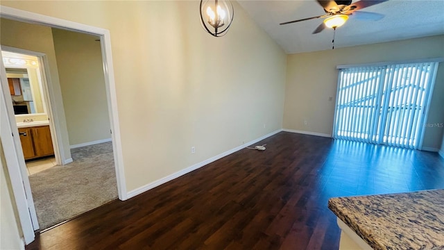 empty room featuring vaulted ceiling, dark hardwood / wood-style floors, sink, and ceiling fan