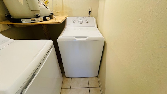 laundry room featuring washer and dryer and light tile patterned floors