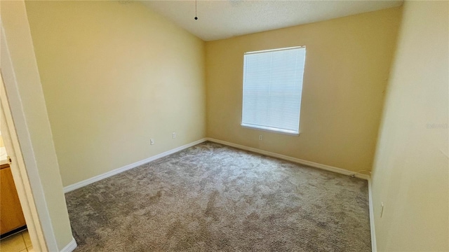 spare room with light carpet and lofted ceiling