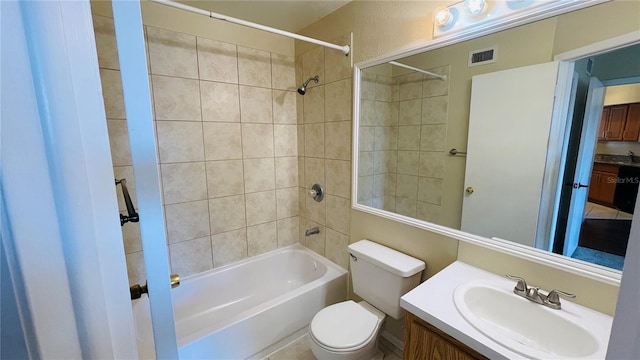 full bathroom with tiled shower / bath combo, vanity, and toilet