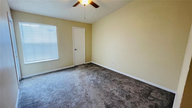 carpeted empty room featuring ceiling fan, plenty of natural light, and a textured ceiling