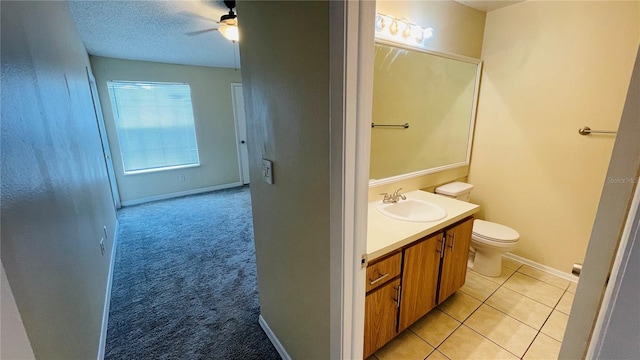 bathroom featuring tile patterned floors, toilet, a textured ceiling, vanity, and ceiling fan