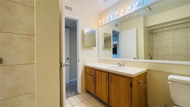 bathroom featuring vanity, tile patterned floors, and toilet