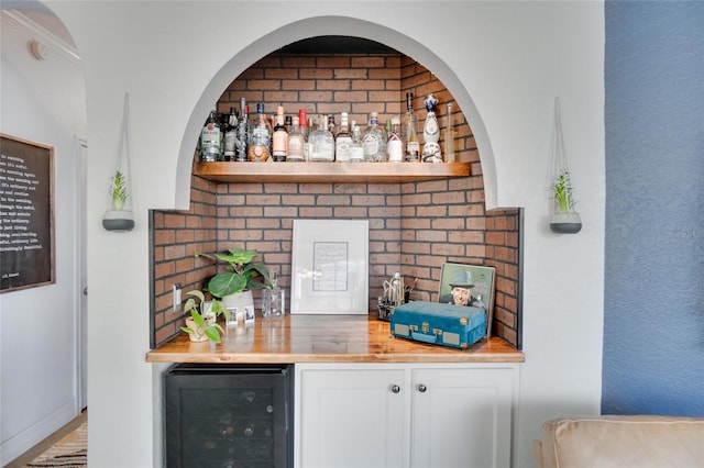 bar with beverage cooler and white cabinets