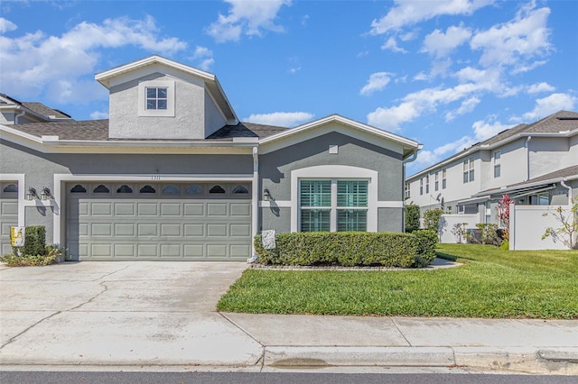 view of front of property with a garage, concrete driveway, roof with shingles, a front lawn, and stucco siding