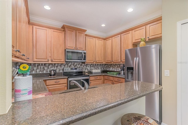 kitchen with dark stone counters, appliances with stainless steel finishes, a breakfast bar area, a peninsula, and backsplash